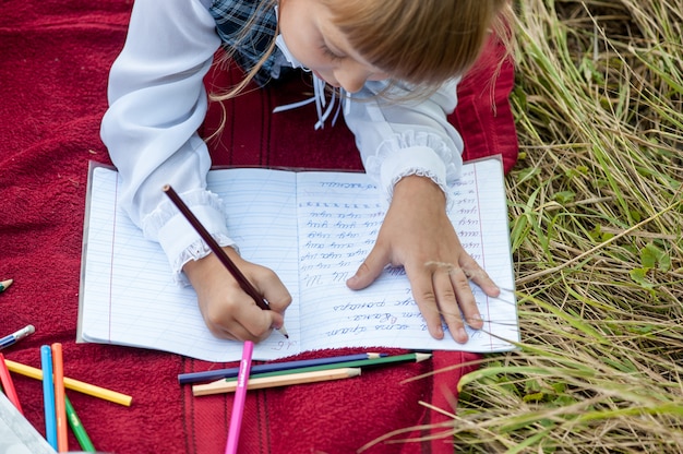 Photo children go to the first class.i study with a letter in the book. school days