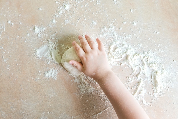 Children hands make dough
