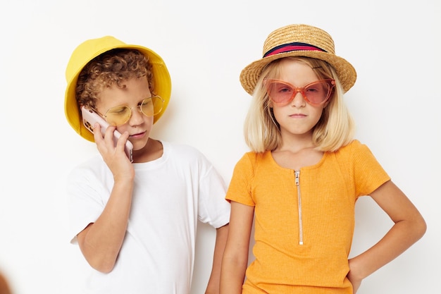 Дети в шляпах с телефоном вместе дружба