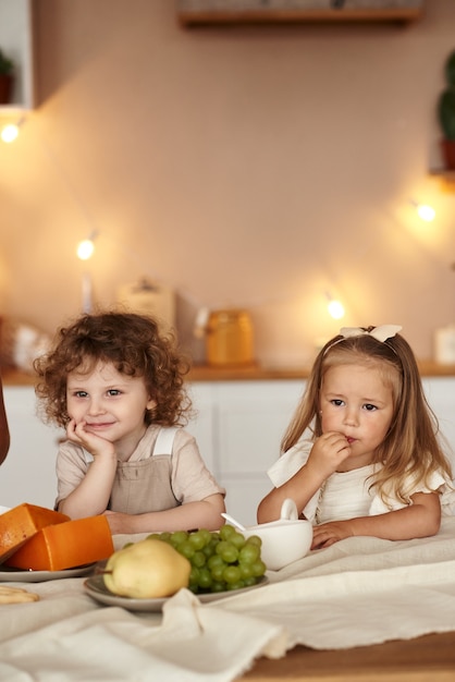 Children have fruit breakfast in the kitchen in the morning.