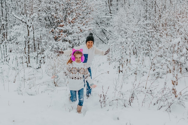 Children have fun playing in the snow. boy and girl running around in winter park. winter holidays