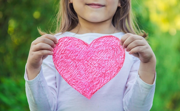 Foto i bambini hanno un cuore nelle loro mani. messa a fuoco selettiva