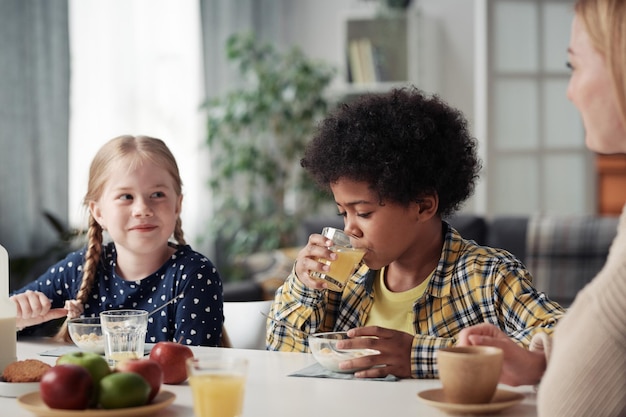 Children having breakfast with mother