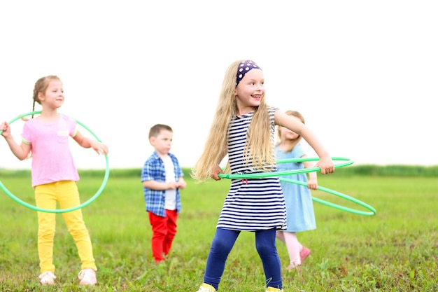 Photo children having fun with hula hoops outdoor