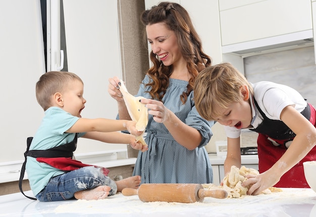 子供たちは若い母親が生地をこねるのを手伝います