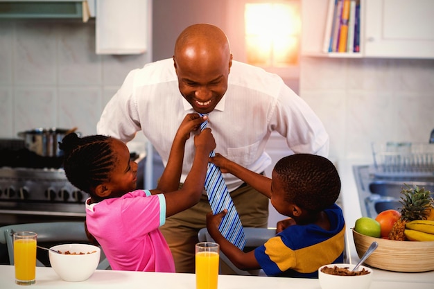 Children helping their father in tying tie