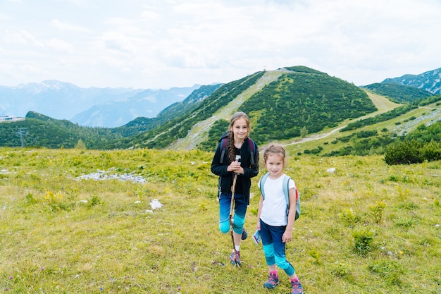 アルプス山脈の美しい夏の日にハイキングの子供