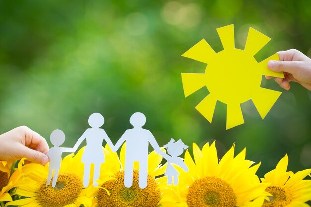 Photo children holding paper family and sun outdoors