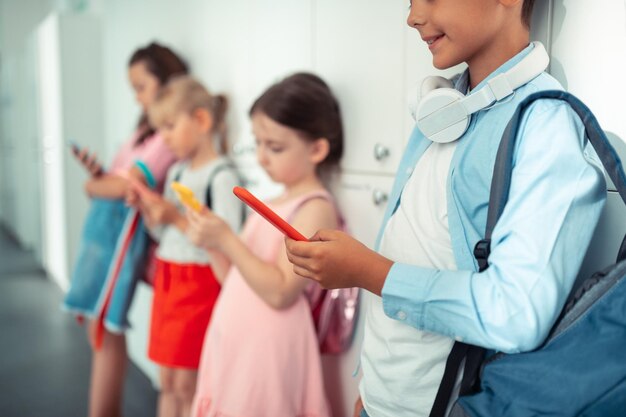 Children holding smartphones while addicted to devices