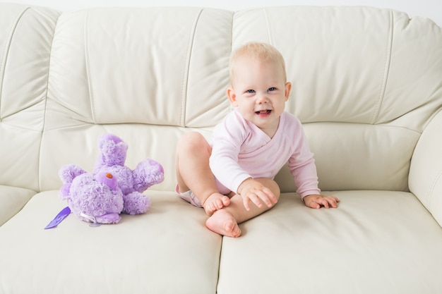 Children, infant and childhood concept - Beautiful cute soft baby sitting on sofa