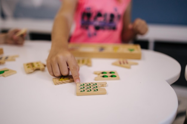 Children in kindergarten put together educational puzzles