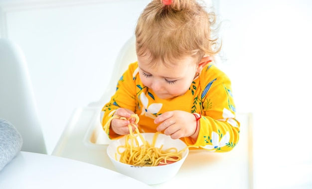 パスタの選択的な焦点を回すテーブルのキッチンの子供たち