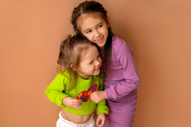 Photo children laugh merrily holding a heart with an autism symbol inside