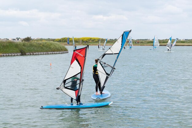 Children learn windsurfing on a lake by the sea