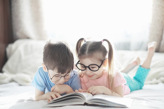 I bambini si trovano sul letto accanto al neonato, sorellina. emozioni dei bambini.