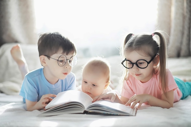 I bambini si trovano sul letto accanto al neonato, sorellina. emozioni dei bambini.