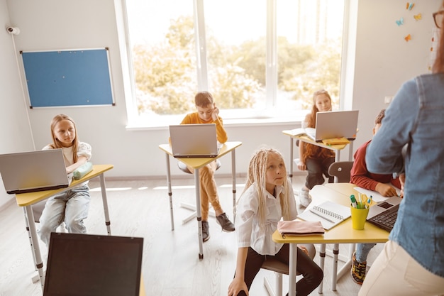 Bambini che ascoltano attentamente l'insegnante a scuola