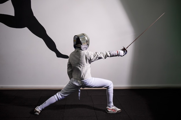 Photo children lunge on swords. a child in a class at a fencing school