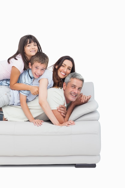 Дети лежат на родителях на диване