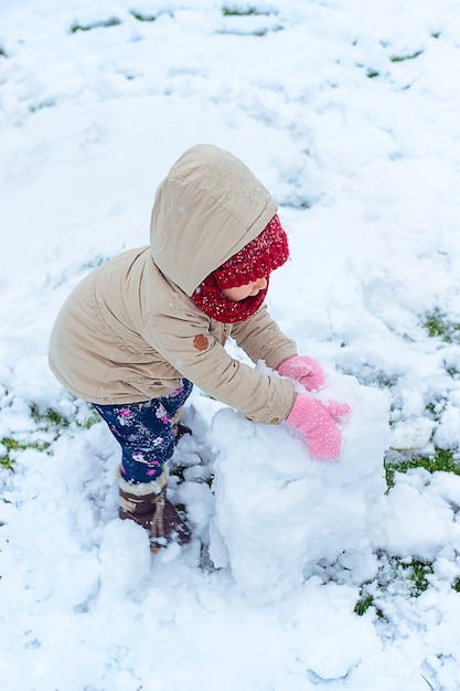 Children make a snowman in winter Selective focus