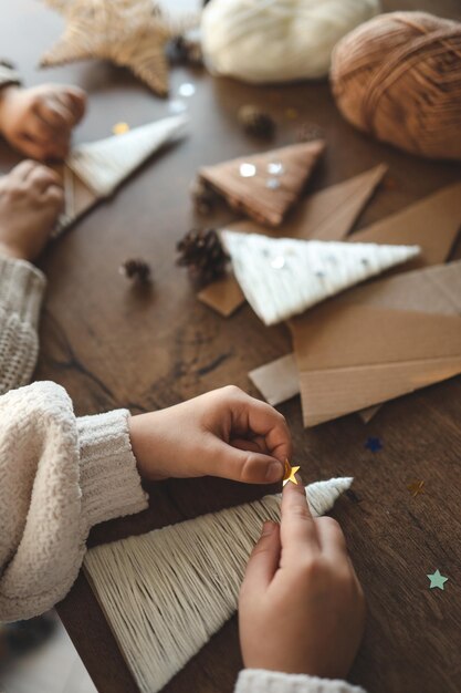 Foto bambini che fanno decorazioni natalizie con il filato