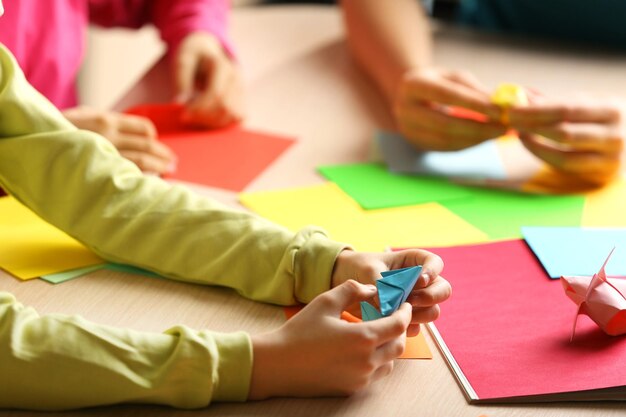 Foto bambini che fanno un cigno con carta colorata