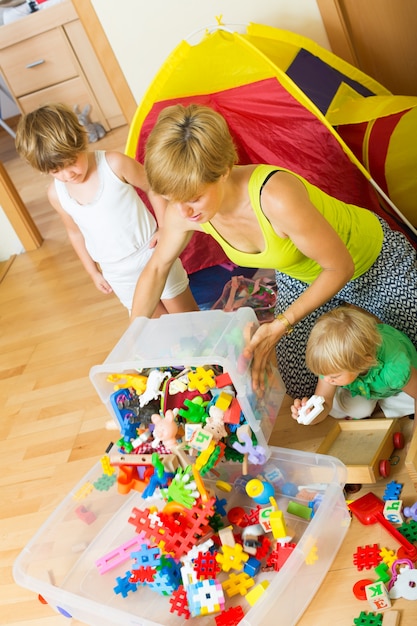 Children and mother collecting toys