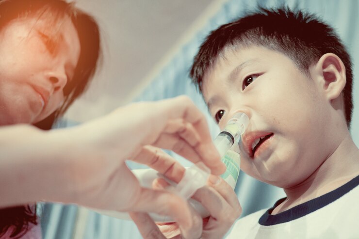 Photo 子供の鼻洗浄、気分が悪い、鼻を掃除する、ヘルスケアの概念、母親が子供の鼻を洗う