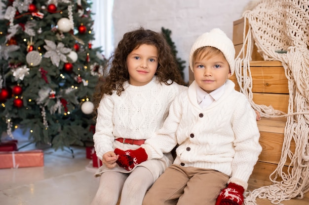 Children near Christmas tree and lights