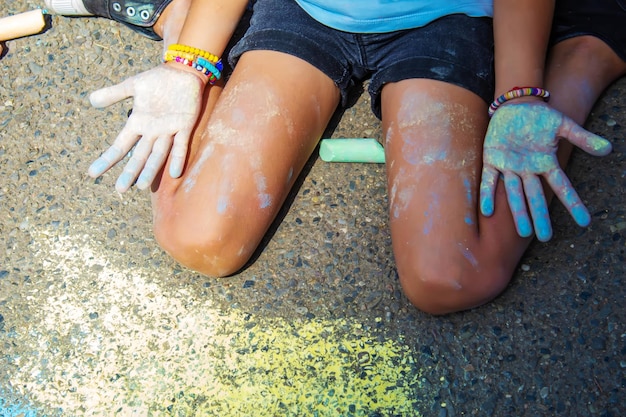 Children paint a rainbow on the asphalt selective focus