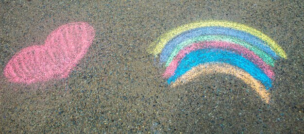 Children paint a rainbow on the asphalt selective focus