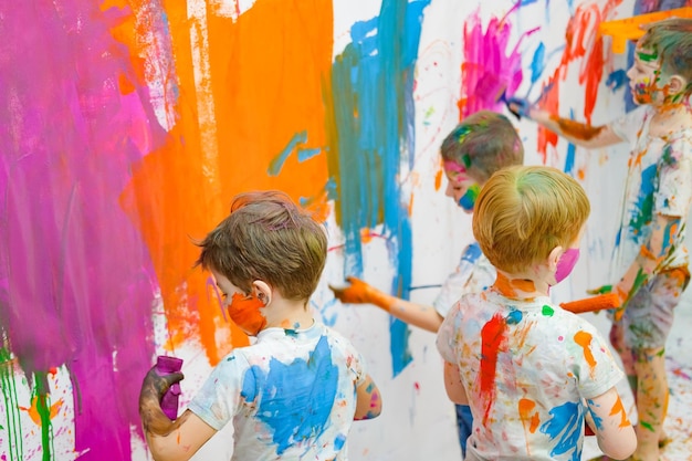 I bambini dipingono sul muro e si divertono con foto di alta qualità