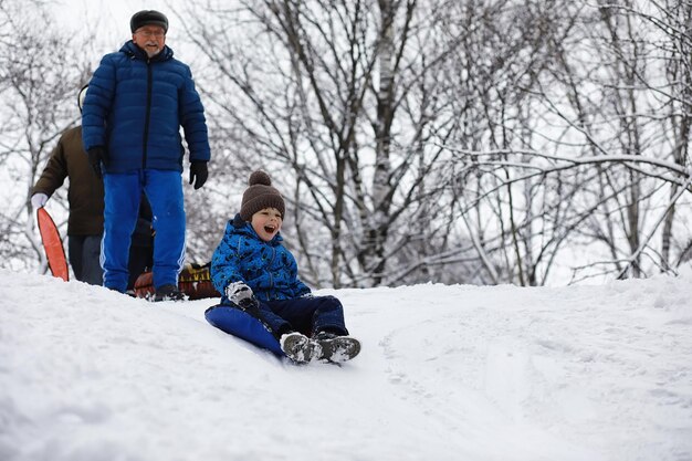 Children in the park in winter Kids play with snow on the playground They sculpt snowmen and slide down the hills