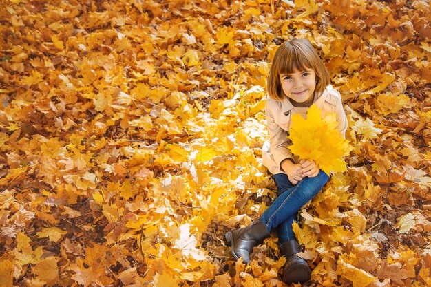 Дети в парке с осенними листьями. Выборочный фокус.