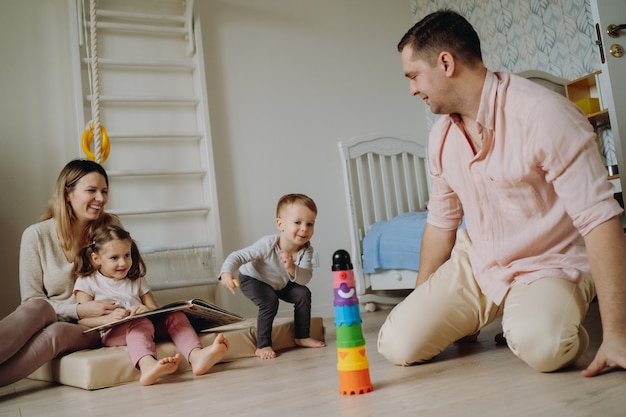 children play in child room Father made a toy pyramide girl reading a book