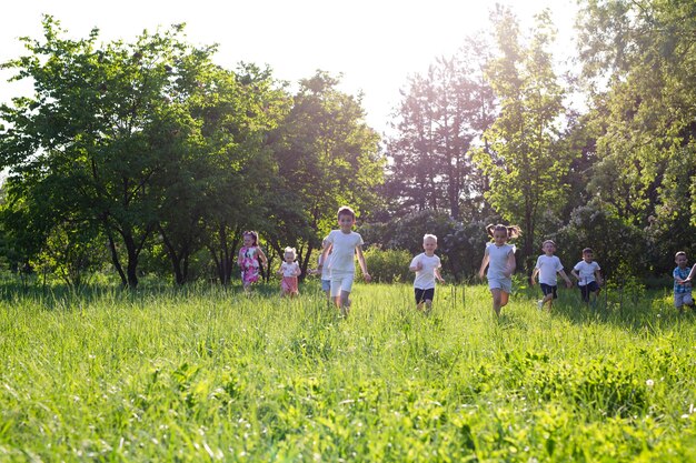 Children play outdoors running and having fun on a grass field