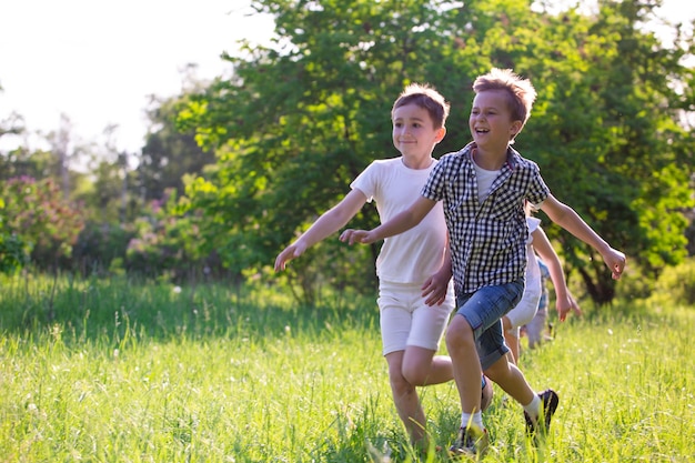 Foto i bambini giocano all'aperto correndo e divertendosi