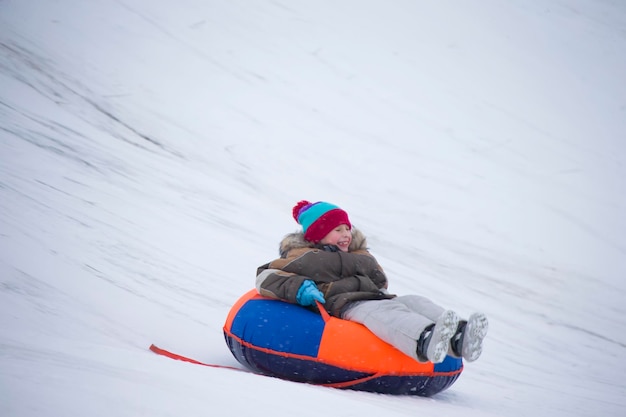 Children play outdoors in snow Kids sled in the Alps mountains in w
