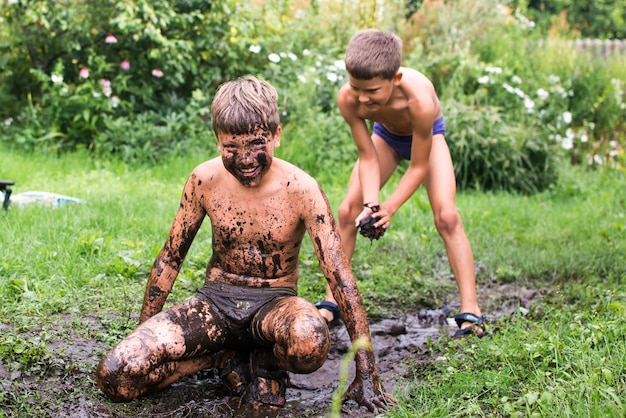 Children play in a puddle, get smeared in the mud. Everything happens during the summer holidays aft