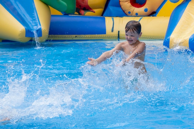 아이들은 수영장에서 놀고 수영하고 아이들은 수영장에서 즐겁게 놀고 있습니다 수영장에서 튀는 친구들 즐거운 여가 시간 여름 방학 개념 수영장에서 노는 귀여운 아이들