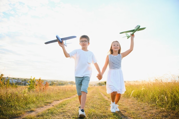 子供たちは、飛行とパイロットになることを夢見る幸せな子供時代のおもちゃの飛行機のコンセプトを果たしています