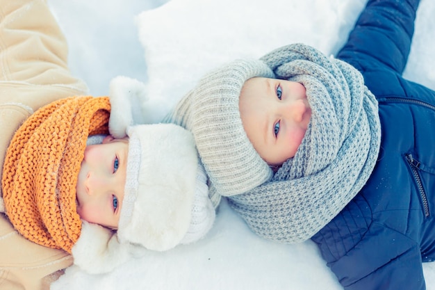 Foto i bambini giocano in un bosco innevato invernale