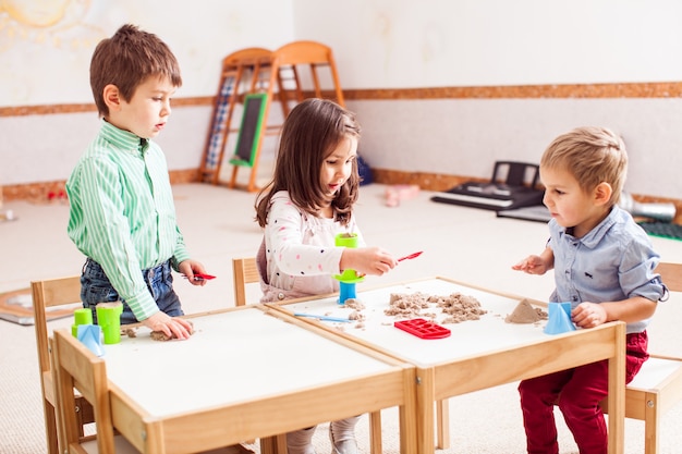 Children play with kinetic sand in the kindergarten