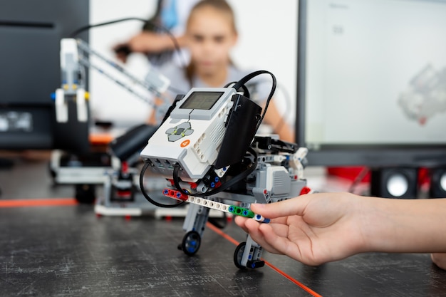 Foto i bambini giocano con un cane robot in una lezione di robotica