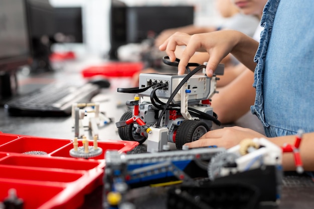 Children play with a robot in a robotics class