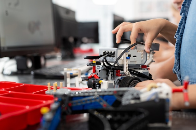 Children play with a robot in a robotics class