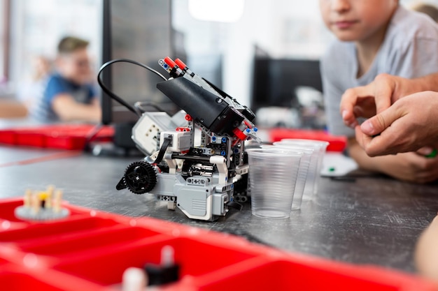 Children play with a robot in a robotics class