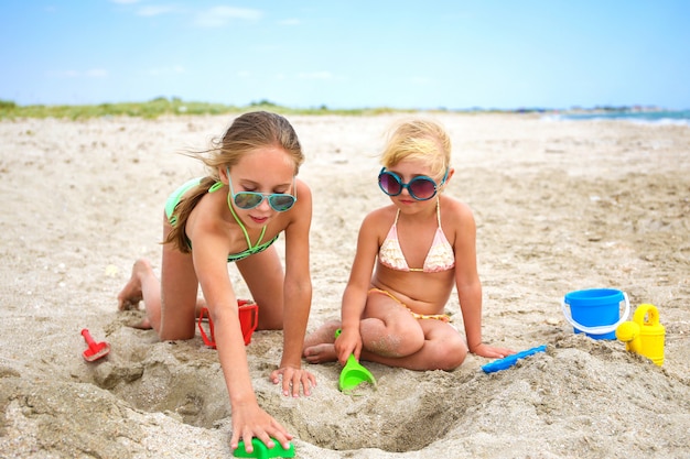 Children play with sand on beach.