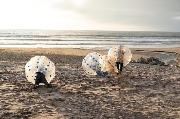 children playing on the beach with inflatable bumper or bubble ball or bumper ball in La Serena