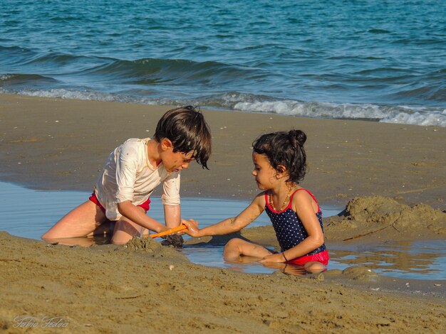 Foto bambini che giocano in spiaggia